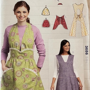 May include: Sewing pattern for a dress and apron. The pattern is for misses sizes S-M-L. The dress is purple and the apron is green with a floral print. The pattern is by Kwik Sew and designed by Kerstin Martensson.