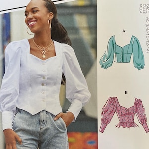 May include: McCall's sewing pattern M8181 featuring a woman wearing a white blouse with a square neckline and puff sleeves. The pattern includes multiple view options. The text "#JenniferMcCalls" is also visible.