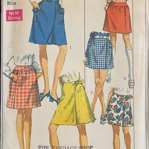May include: A vintage Simplicity sewing pattern for a mini skirt. The pattern number is 8100 and the price is 65 cents. The pattern includes six different views of the skirt, including a plaid skirt, a yellow skirt, a floral skirt, and a blue skirt.