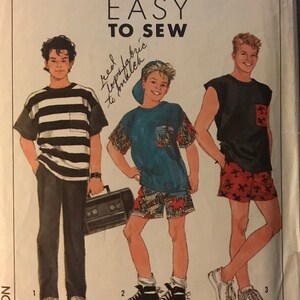 May include: Simplicity sewing pattern number 9174 for easy to sew boys' clothing. The pattern includes three different styles: a striped shirt with black pants, a colorful shirt with shorts, and a sleeveless shirt with red and white patterned shorts. The pattern is labeled "Surf Club" and includes instructions for using an overlock/serger machine.