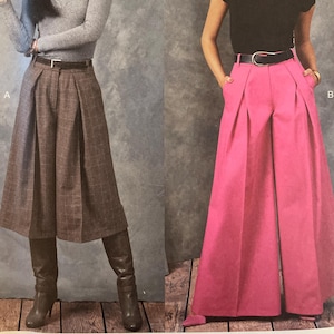 May include: Vogue Patterns sewing pattern featuring two women modeling different outfits. One woman wears a gray turtleneck, brown plaid skirt, and boots. The other wears a black top and pink wide-leg pants. The pattern number is V1910.