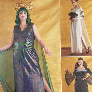 Peut inclure: Patron de couture Simplicity Costumes avec trois modèles de costumes. Les costumes comprennent une longue robe violette irisée avec une cape verte, une robe blanche avec une cape et une robe en velours noir avec des manches en dentelle. Taille du patron : 48-56.