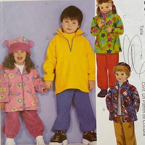 May include: A white ceramic mug with a black handle and the text "But First, Coffee" in a bold, black font. The mug is set against a blurred background, suggesting a cozy setting.