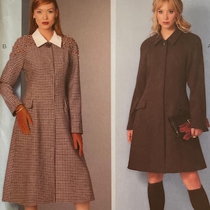 May include: Vogue Patterns sewing pattern featuring two coat designs. One coat is a brown and white checked pattern with a white collar. The other coat is a solid brown colour. The pattern includes sizes 8-16.