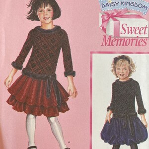 May include: Simplicity sewing pattern 4065 featuring two girls' dresses. The dresses have long sleeves, a textured bodice, and a layered skirt. The pattern includes sizes AA 3, 4, 5, and 6. The cover has the text "Sweet Memories".