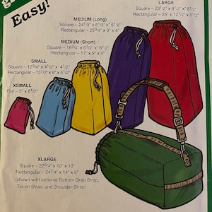 May include: A set of green, red, purple, and yellow drawstring stuff sacks in various sizes. The sacks are labeled with their dimensions in inches. The text "Easy!" is printed in green on a white background. The text "Green Pepper Inc." is printed in green on a white background. The text "F874" is printed in black on a white background. The text "USA $6.00" is printed in black on a white background. The text "CAN $10.00" is printed in black on a white background. The text "Stuff Sacks" is printed in black on a white background. The text "Rugged Stuff Sack for Camping, Travel, or Biking" is printed in black on a white background. The text "Available in a variety of sizes with these convenient options:" is printed in black on a white background. The text "Square or rectangular bottom. Inner flap for added protection." is printed in black on a white background. The text "Tie-Down Strap with Grip Handle plus detachable Shoulder Strap." is printed in black on a white background. The text "Bottom Grab Strap for easy cargo removal." is printed in black on a white background.