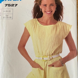 May include: A yellow sleeveless dress with a white belt and two pockets. The pattern number is 7527 and the size is 8-10-12 or 36-38-40.
