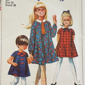 May include: Simplicity sewing pattern number 7331 for a girl's dress. The pattern includes three different styles of dresses, one with a floral print, one with a plaid print, and one with a solid blue colour. The pattern is for a size 10 with a 28 inch bust.