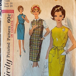 May include: Vintage Simplicity sewing pattern number 5420 for a teen size 14 dress with a bust measurement of 86 cm. The pattern includes three different dress styles: a blue dress with a white collar, a plaid dress with a white collar, and a yellow dress with a white collar and a sash.