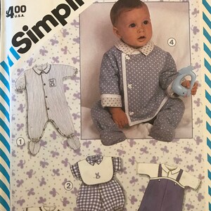 May include: Simplicity sewing pattern number 6256 for baby clothes. The pattern includes four different outfits: a blue and white striped sleeper, a blue and white polka dot sleeper, a white and blue gingham romper with a bib, and a blue and white striped overall.