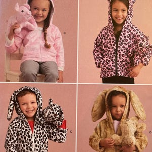 May include: Simplicity sewing pattern S9391 showing children's hooded jackets with animal ear details. The pattern includes sizes 1/2-4. The jackets are shown in pink, black and white, and brown, with matching stuffed animals. Designed and printed in the USA.