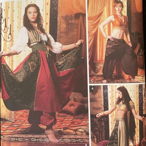 May include: A sewing pattern for adult costumes. The pattern includes three different costumes: a red and black skirt with a gold vest, a black and gold top with black pants, and a gold top with a black and gold skirt. The pattern is from Simplicity and is for sizes 6, 8, 10, and 12.