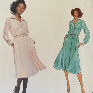 May include: Vogue American Designer sewing pattern featuring two dress designs. The pattern includes a light pink dress and a teal dress, both with long sleeves and belted waists. The pattern is by Jerry Silverman, pattern number 1829.