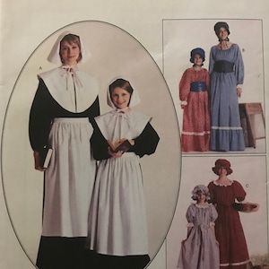 May include: A sewing pattern for a colonial-style dress. The pattern includes three different styles of dresses, all with long sleeves and a gathered skirt. The pattern is for size 14 and is from McCall's Costumes.