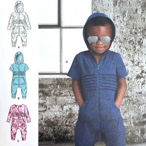 May include: A Simplicity pattern envelope featuring a child wearing a blue jumpsuit with a hood and sunglasses. The pattern includes illustrations of different jumpsuit styles. The text "S9486" and "Simplicity" are visible.