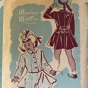 May include: Vintage sewing pattern for a girl's dress, size 6. The pattern is from Marian Martin Pattern and features a blue and white dress with a matching hat. The pattern also includes a burgundy dress with a matching hat.