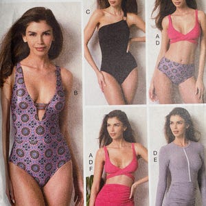 May include: Vogue Patterns sewing pattern featuring swimwear designs. The pattern includes options for a one-piece swimsuit, a bikini set, and a long-sleeved ruched dress. The pattern number is V9192, and the size range is E5 (14-16-18-20-22).