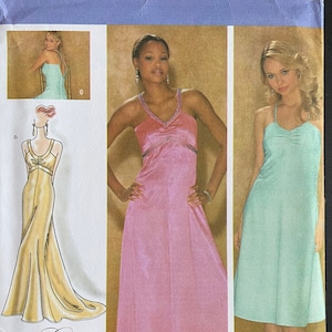 May include: Simplicity sewing pattern number 4215 for a dress. The pattern includes three different styles: a long, flowing dress with a sweetheart neckline, a long, flowing dress with a V-neckline, and a shorter dress with a scoop neckline. The pattern is for sizes H5 6, 8, 10, 12, and 14. The pattern is for women's clothing.