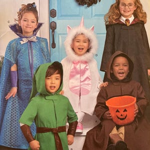 May include: Simplicity sewing pattern 8483 featuring children in Halloween costumes. The costumes include a fairy, a unicorn, a wizard, and a character in a green tunic. The pattern includes sizes S-L. The pattern is designed and printed in the USA.