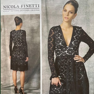 May include: Vogue pattern for a Nicola Finetti designer dress. The pattern features a black lace dress with long sleeves and a V-neckline. The dress has a fitted bodice and a flared skirt. The pattern number is V1471, and the size range is 14-22.