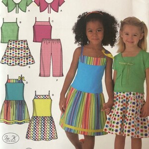 May include: A sewing pattern for children's clothing, Simplicity pattern number 4252, size A 3, 4, 5, 6, 8. The pattern includes a dress, skirt, top, pants, and a cropped top. The pattern is easy to sew and includes instructions for making each garment.