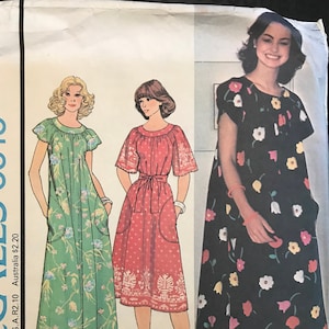 May include: A vintage McCall's sewing pattern envelope featuring illustrations of three different dresses. The dresses are in green, red, and black, with floral and patterned designs. The envelope includes text indicating sizes and the pattern number 5919.