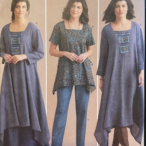 May include: Simplicity sewing pattern S8960 featuring three different garment styles. The pattern includes a long-sleeved dress, a short-sleeved top with pants, and a long dress with a unique hemline. The models are wearing blue and patterned fabrics.