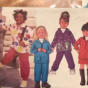 May include: A sewing pattern for children's clothing. The pattern includes three different outfits: a floral print top and trousers, a blue jacket and trousers, and a red sweater and skirt. The pattern is from the brand Butterick and has the number 3269.