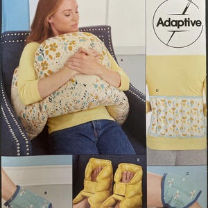 Peut inclure: Patron de couture Simplicity S9494, avec un design adaptatif. Le patron comprend des instructions pour un coussin d'allaitement, des attelles de cheville et des chauffe-pieds. L'image montre une femme utilisant le coussin. Imprimé aux États-Unis.