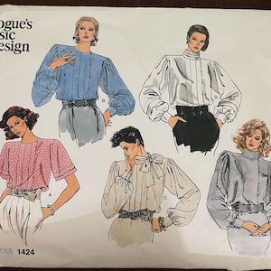 May include: Vogue's Basic Design pattern 1424 featuring four different blouse styles. The blouses are shown in blue, white, pink, and gray. Each blouse has a different neckline and sleeve style.