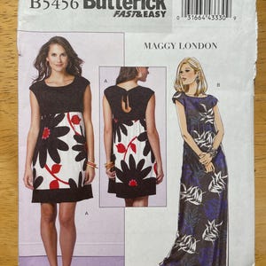 May include: A Butterick sewing pattern, B5456, featuring three dress designs by Maggy London. The pattern includes a short black and white floral dress, a dress with a keyhole back, and a long blue and white leaf-patterned dress.