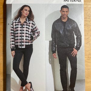 May include: Vogue Patterns R11316 sewing pattern. The cover shows two models in jackets and trousers. One jacket is black, the other a black and pink plaid. The pattern size is XM (SML-MED-LRG).