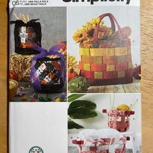 May include: Simplicity sewing pattern S9623 featuring various basket designs. The image showcases several fabric basket projects, including a woven basket with sunflowers and smaller decorative baskets with different patterns and colors.
