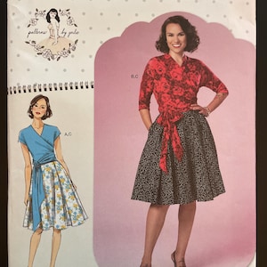 May include: Simplicity sewing pattern with illustrations of women's clothing designs. The pattern includes a red floral wrap top, a black and white patterned skirt, and a blue wrap dress with a floral skirt. The pattern size is Euro 40-48.