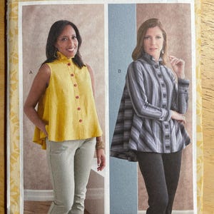 May include: Butterick sewing pattern B6792 featuring two women modeling blouses. One blouse is yellow with red buttons, the other is striped. The pattern includes the text "kAtHeRinE Tilton" and size information.