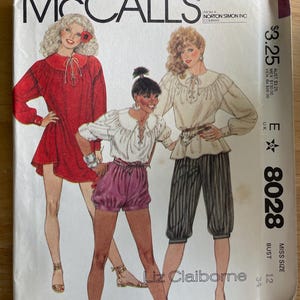 May include: A McCall's sewing pattern envelope 8028 for Liz Claiborne designs. The cover features illustrations of three outfits: a red long-sleeve tunic, a white blouse with purple shorts, and a white blouse with black pinstriped knickers.