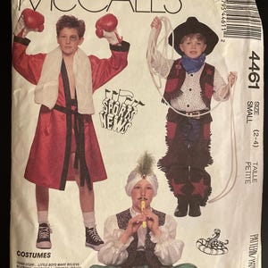 May include: McCall's pattern for children's costumes, featuring a boxer in a red robe, a cowboy with a rope, and a prince playing a flute. The pattern is size small (2-4).