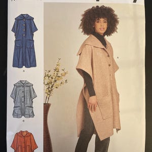 May include: Simplicity sewing pattern S9649 featuring a hooded cape with pockets. The pattern includes size options from S to XXL. The image shows a woman wearing a light brown cape. The pattern also shows a denim, gray, and orange cape.