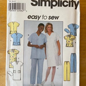 May include: A Simplicity sewing pattern for a scrub top and pants. The pattern includes three different styles: a solid blue scrub top and pants, a white scrub top with a floral print, and a yellow scrub top with a floral print. The pattern is for sizes XS, S, and M. The pattern number is 8336.