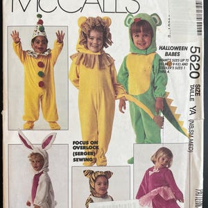 May include: A vintage McCall's sewing pattern featuring Halloween costumes for babies and toddlers. The pattern includes designs for a clown, lion, dragon, bunny, tiger, and ballerina. The pattern sizes range from infant to toddler.