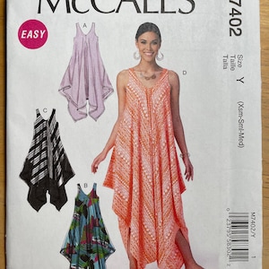 Peut inclure: Patron de couture McCall's M7402. Le patron propose quatre modèles de robes, dont une robe sans manches à ourlet asymétrique. La couverture montre une femme portant une robe corail. Le mot "EASY" est dans un cercle rose.