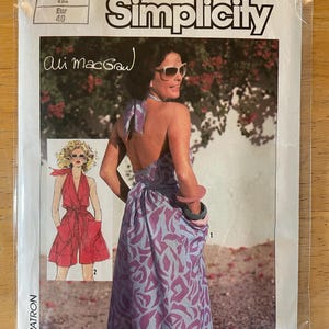 May include: Simplicity sewing pattern number 6888 for a halter dress designed by Ali MacGraw. The pattern includes two views: a short red jumpsuit with pockets and a long purple floral print dress with a wrap skirt.