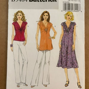 May include: A sewing pattern for a dress with three different styles. The pattern is for sizes 8-10-12-14. The pattern is called "The Cut Line: Dress to Top Options".