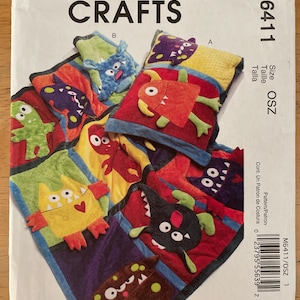 May include: McCall's Crafts pattern M6411 featuring colorful monster-themed appliqués. The pattern includes various sizes and designs, with the text "Size OSZ" visible. The cover showcases finished projects with vibrant colors and playful monster shapes.