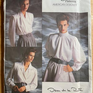 May include: Vogue Patterns American Designer sewing pattern featuring three blouse designs by Oscar de la Renta. The pattern envelope shows women wearing white blouses with black belts and grey skirts. The pattern number is 1913.
