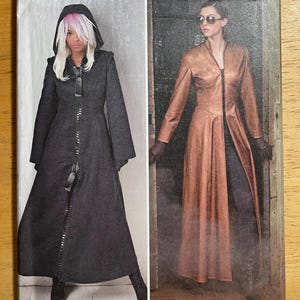 May include: Simplicity pattern 8482 features two long coat designs. One coat is dark gray with a hood and zipper closure. The other coat is a copper color with a zipper closure. The pattern size is U.S. 14-22.