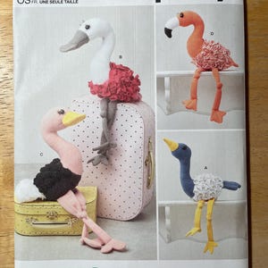 Peut inclure: Un patron de couture Simplicity avec des modèles d'oiseaux en peluche. Le patron comprend des instructions pour créer un flamant rose, une autruche et d'autres jouets en peluche d'oiseaux. Les oiseaux ont des détails colorés.