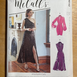 May include: McCall's sewing pattern envelope featuring a woman in a sequined one-shoulder gown. The envelope includes illustrations of two dress designs, a pink dress with long sleeves and a purple dress. The text on the envelope includes the size range and the hashtag #NolitaMcCalls.