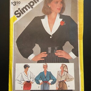 Peut inclure: Patron de couture Simplicity numéro 6127 pour un chemisier femme. Le patron comprend trois vues différentes du chemisier, avec un col blanc et une broche de fleur rouge. Le patron est vendu au prix de 3,50 €.