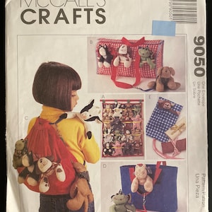 Peut inclure: Patron de couture McCall's Crafts avec des illustrations de divers projets d'animaux en peluche. Les projets comprennent un sac à dos rouge avec des animaux en peluche attachés et un sac fourre-tout bleu.
